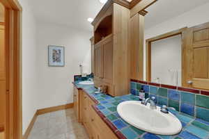Bathroom featuring double vanity and tasteful backsplash
