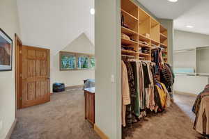 Walk in closet with carpet and lofted ceiling