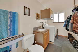 Bathroom with washing machine and clothes dryer and vanity