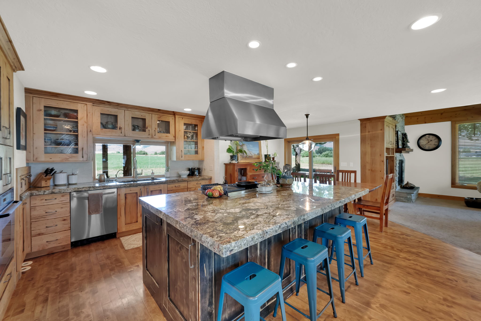 Kitchen featuring recessed lighting, a center island, a breakfast bar area, island range hood, and light wood-style flooring