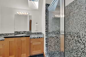 Full bathroom featuring vanity, a shower stall, and decorative backsplash