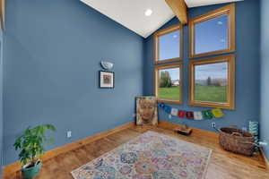 Living area featuring high vaulted ceiling, wood finished floors, beam ceiling, and recessed lighting