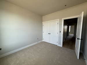 Unfurnished bedroom with carpet and a closet
