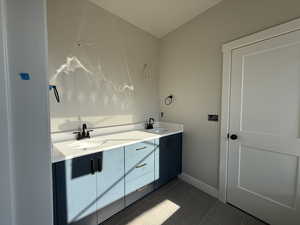 Bathroom with double vanity and tile patterned flooring