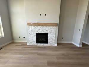 Unfurnished living room with light wood-type flooring and a fireplace