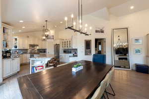 Dining space featuring a chandelier, lofted ceiling, light wood-style floors, and recessed lighting