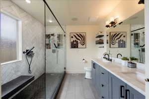 Full bath with healthy amount of natural light, double vanity, tiled shower, wood finished floors, and recessed lighting