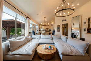 Living area featuring a chandelier, recessed lighting, and high vaulted ceiling