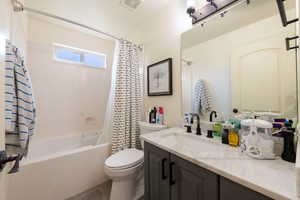 Full bathroom with shower / bath combo with shower curtain and vanity