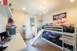 Bedroom featuring a chandelier, recessed lighting, and wood finished floors