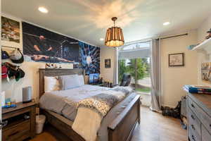 Bedroom with a chandelier, wood finished floors, and recessed lighting