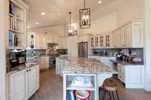 Kitchen with open shelves, a kitchen island, dark wood finished floors, decorative backsplash, and high vaulted ceiling