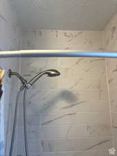 Bathroom view of tiled shower and a textured ceiling