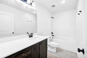 Bathroom with vanity, washtub / shower combination, tile patterned flooring, and recessed lighting