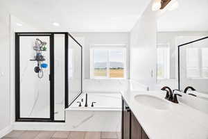 Bathroom with a shower stall, vanity, a garden tub, and tile patterned floors