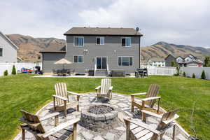 Back of house with a fire pit, entry steps, a patio area, a mountain view, and a fenced backyard