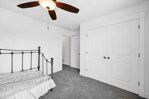 Carpeted bedroom with a closet and a ceiling fan