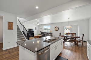Kitchen with dark countertops, stainless steel dishwasher, dark wood-style floors, and recessed lighting