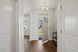 Entrance foyer featuring wood finished floors, a chandelier, and a textured ceiling