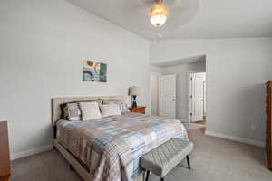 Bedroom featuring lofted ceiling, light colored carpet, and a ceiling fan