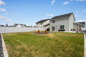 Rear view of property with a patio area, a fenced backyard, a fire pit, and stucco siding