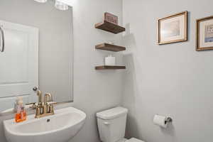 Half bathroom featuring toilet and a sink