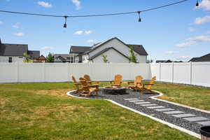 Fenced yard with a fire pit and a residential view