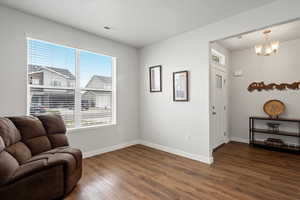 Living area featuring a chandelier and dark wood-style floors