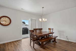 Dining area with wood finished floors and a chandelier
