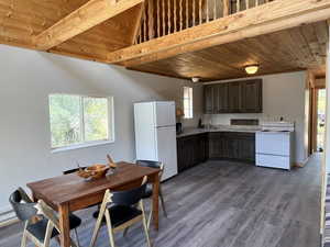 Kitchen featuring wooden ceiling, white appliances, light countertops, dark wood finished floors, and dark brown cabinets
