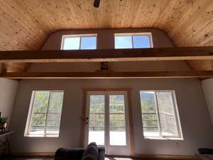 Living area featuring lofted ceiling, plenty of natural light, wood ceiling, and ceiling fan