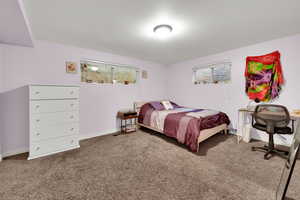Bedroom featuring carpet and baseboards