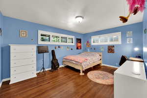 Bedroom featuring wood finished floors and baseboards