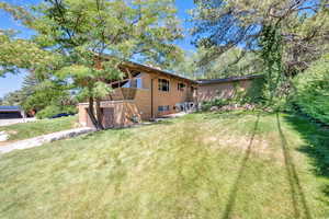 View of property exterior featuring an attached garage, a yard, and brick siding