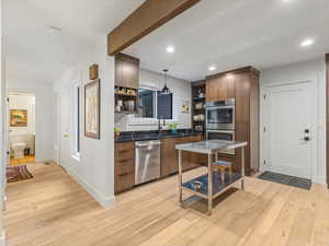Kitchen with short hall to powder room, passing front door