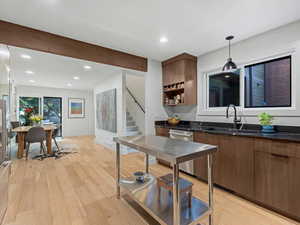 Kitchen with dark quartz countertops, Bosch and Fisher & Paykel Appliances, and small industrial work table
