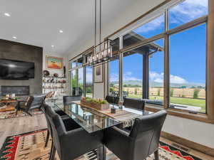 Dining room featuring wood finished floors, recessed lighting, a large fireplace, and a mountain view