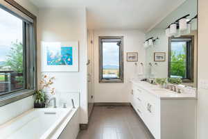 Bathroom featuring double vanity, a bath, a shower stall, and tile patterned flooring