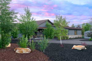 View of front of property featuring a patio and stone siding