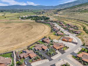 Aerial view of property and surrounding area featuring mountains and nearby suburban area