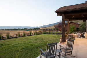 Fenced backyard featuring a mountain view and a view of rural / pastoral area