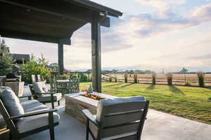 View of patio featuring a rural view and an outdoor living space with a fire pit