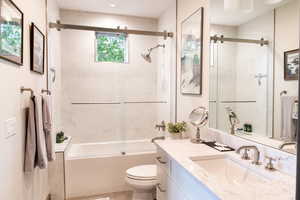 Full bath with vanity and combined bath / shower with glass door