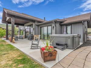 View of patio featuring a hot tub and a grill