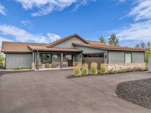 View of front facade with stone siding, concrete driveway, and a garage