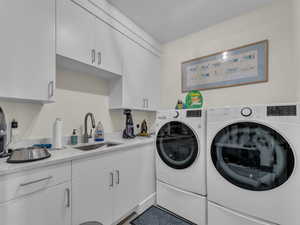 Laundry area featuring washing machine and clothes dryer and cabinet space