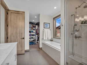 Bathroom with a bath, a shower stall, tile patterned flooring, vanity, and recessed lighting