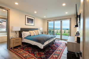 Bedroom featuring access to exterior, wood finished floors, and recessed lighting
