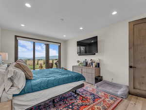Bedroom featuring access to exterior, light wood finished floors, and recessed lighting