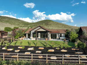 Back of house featuring a fenced backyard, a patio, and a mountain view